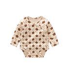 Baby onesie with brown apple pattern on a white background